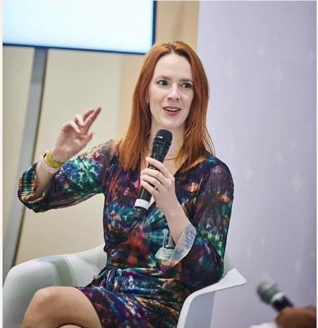 Rosie Rapp speaking on a panel with a microphone